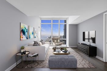 A modern living room with a large window and a grey sofa.